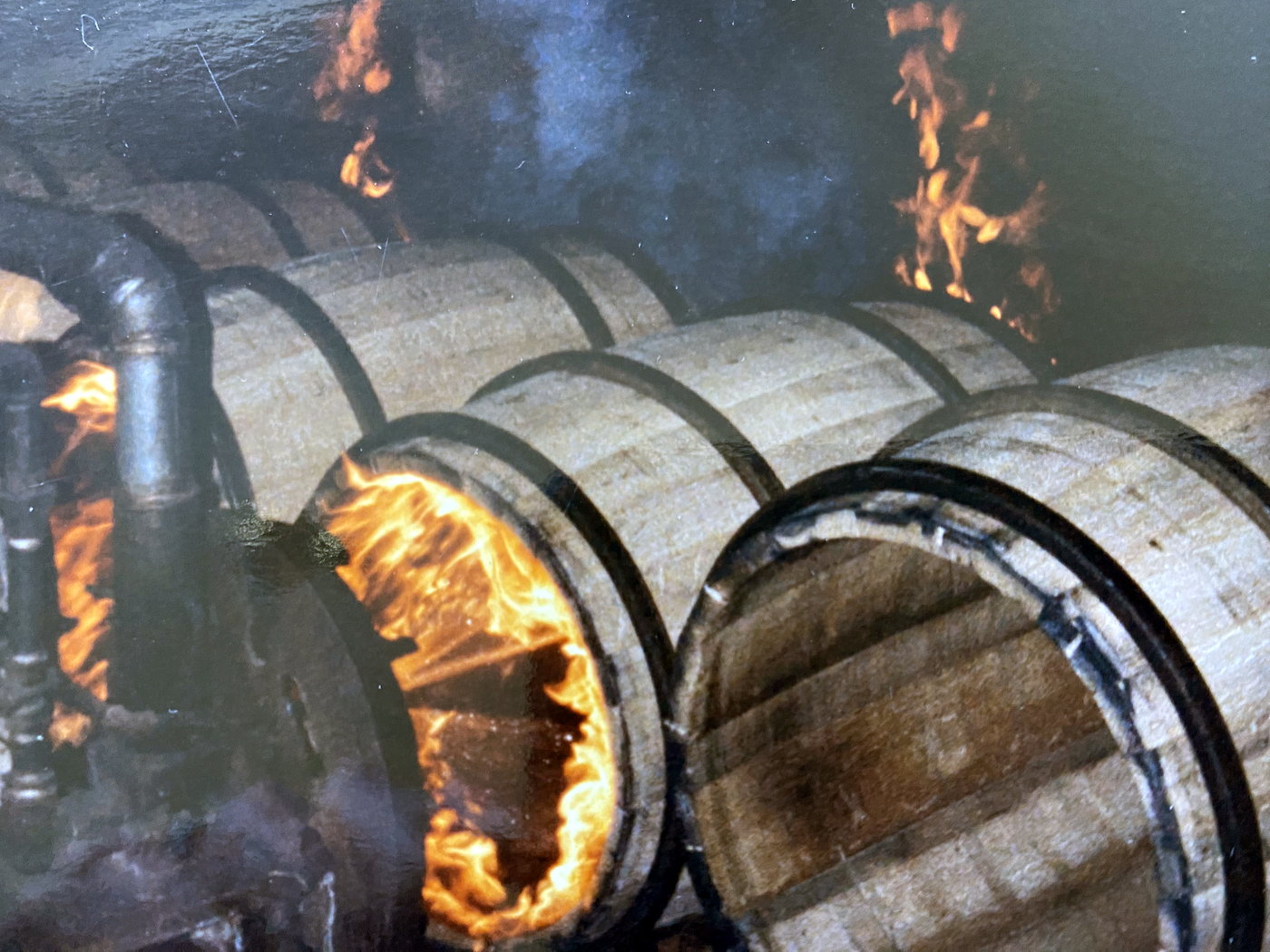 Casks being fired, with flame inside the staves.
